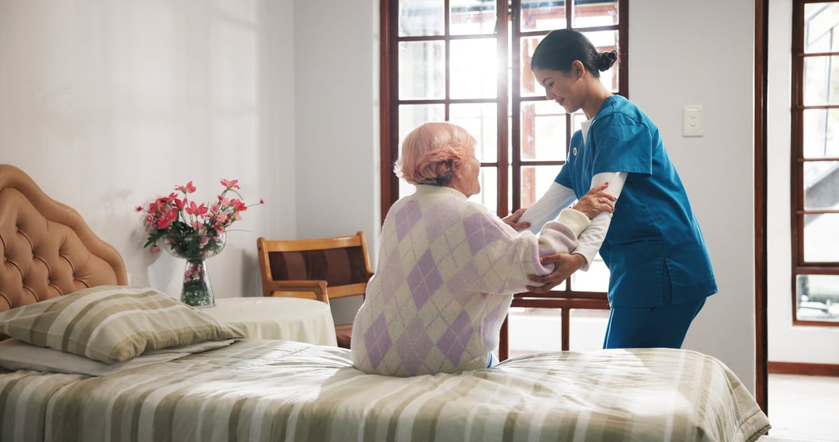 Senior woman, caregiver and help on bed with care, assisted living and support